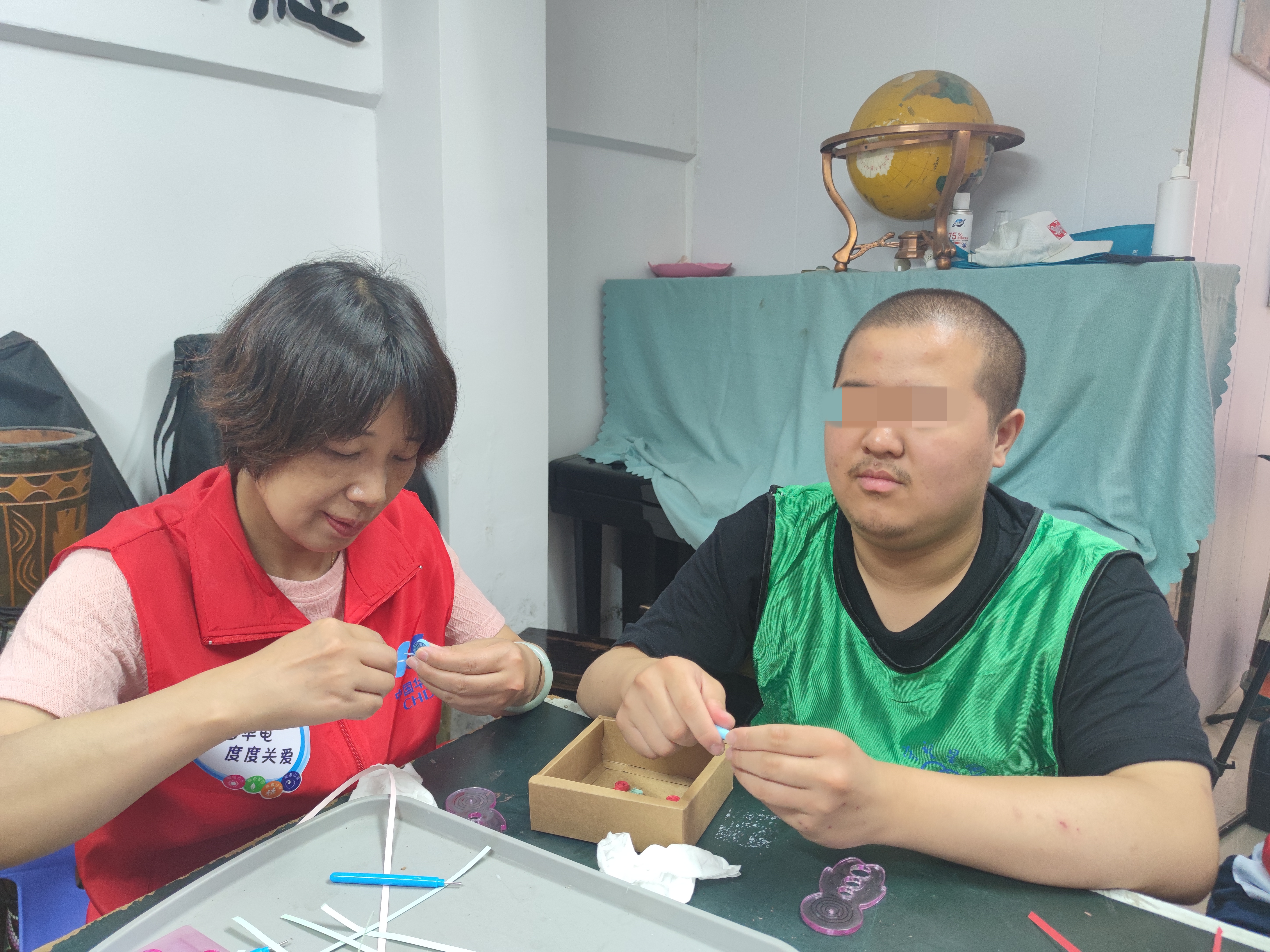 段小民與“守望星園”自閉癥兒童一起編制手工飾品.jpg