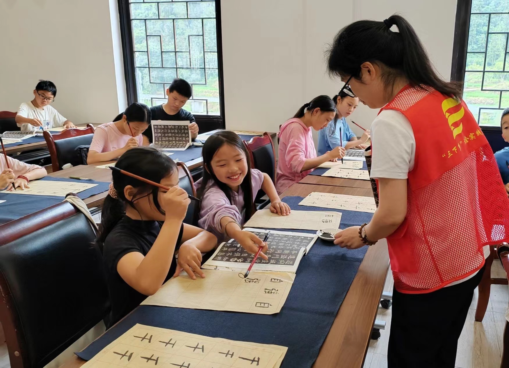 图为实践队指导教师教留守儿童学习毛笔书法.jpg