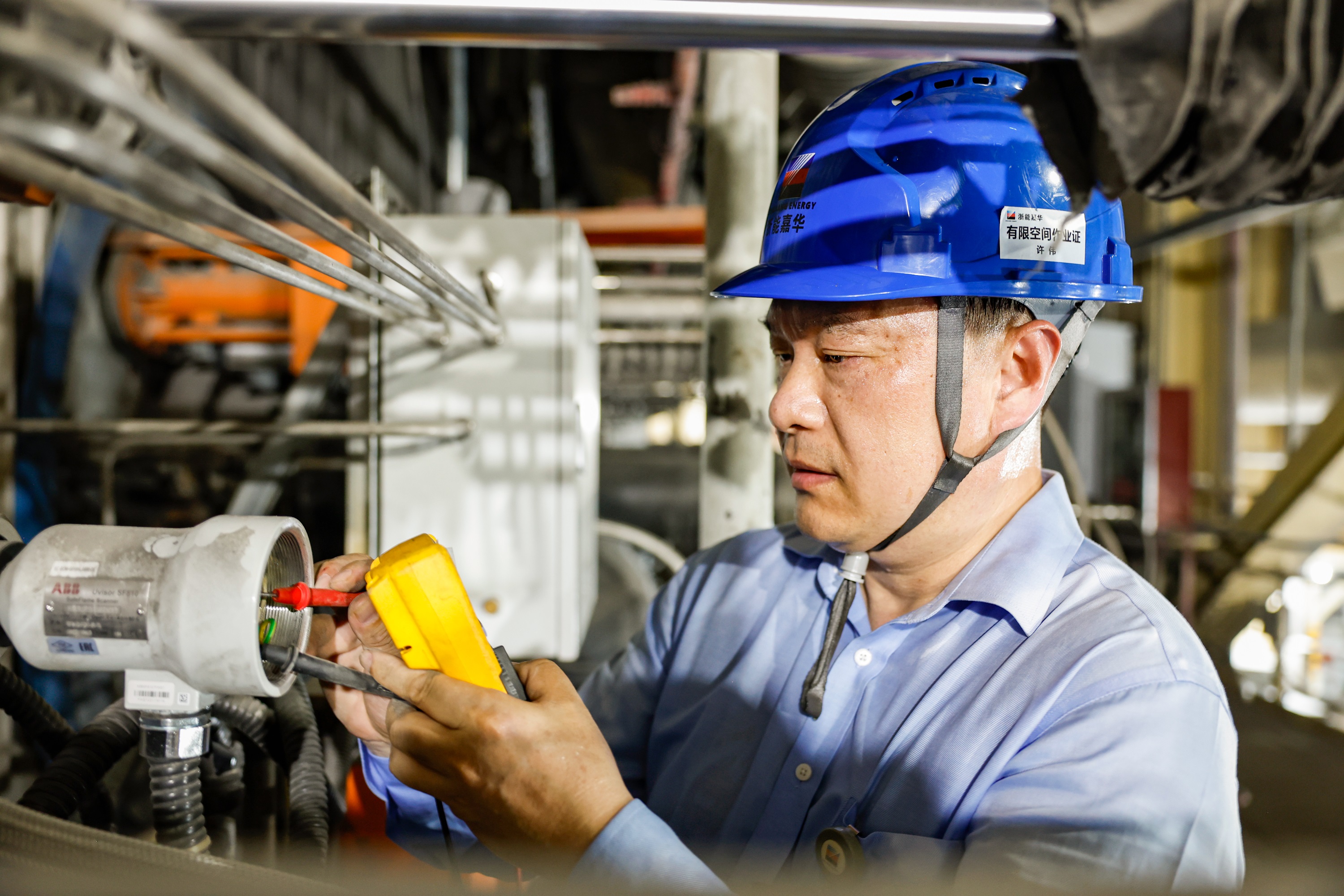 浙能集团嘉兴发电厂仪控一班工作人员正冒着高温进行设备消缺工作。王重阳 摄2.jpg